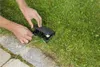 Hands working on a black junction box in the grass next to a stone path. Produktbild-Vorschau