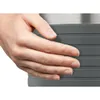 A hand is shown resting on a textured gray surface, with a metallic silver surface visible above. Podgląd zdjęcia produktu