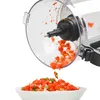 A food processor bowl is shown tilted, with chopped tomatoes and herbs falling into a white bowl below. Anteprima dell’immagine prodotto