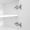 Close-up view of the interior of a white cabinet, showing two metal hinges attached to the cabinet door and frame, and a white shelf. Náhled obrázku produktu