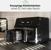 A black double-chamber air fryer is placed on a countertop. Voir les images du produit