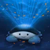 A plush crab toy projecting light and small fish into a blue underwater environment. Náhled obrázku produktu