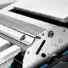 A close-up view of a metal component with intricate detailing, possibly part of a machine or tool. Voir les images du produit