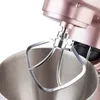 A close-up view of a rose gold stand mixer's beater attachment and bowl. Podgląd zdjęcia produktu