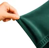 A hand is stretching a piece of dark green fabric, likely a sofa cover. Podgląd zdjęcia produktu