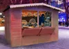 A wooden market stall or garden bar set up outdoors in a snowy environment, decorated with lights. Náhľad obrázku produktu