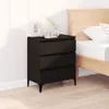 A black three-drawer dresser is placed next to a wooden bed frame in a bedroom setting. Anteprima dell’immagine prodotto