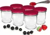A set of six empty glass jars with red lids, along with some blackcurrants and strawberries, and a spoon with jam. Podgląd zdjęcia produktu