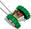 A close-up, angled view of a seed planter with a transparent hopper filled with seeds. Produktbild-Vorschau
