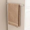 A brown towel hanging on a towel rack in a bathroom. Produktbild-Vorschau