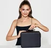 A woman is holding a black cosmetic case. Produktbild-Vorschau