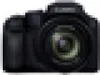 A black digital camera is shown from the front. Produktbild-Vorschau
