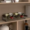A wine rack holding several bottles of wine on a shelf, with a vase and decorative plant on the shelf below. Náhled obrázku produktu
