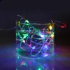A string of colorful LED lights submerged in water inside a clear glass. Produktbild-Vorschau