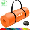 An orange yoga mat rolled up and held by a black strap, with a logo and text on it. A row of different colored mats is visible at the bottom. Podgląd zdjęcia produktu