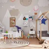 A child's bedroom decorated with a mountain and celestial theme, featuring a bed, table, chairs, and various toys. Podgląd zdjęcia produktu