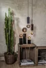 A tall cactus in a basket is placed next to wooden crates with decorative lamps and books. Podgląd zdjęcia produktu