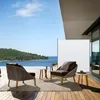 An outdoor patio with furniture and a view of the ocean. Produktbild-Vorschau
