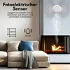 A living room scene with a couch and fireplace, featuring a smoke detector on the wall. Produktbild-Vorschau