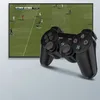 A black PS3 controller is placed in front of a television screen displaying a soccer game. Podgląd zdjęcia produktu