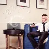 A man is relaxing on a couch while listening to music from a speaker. Produktbild-Vorschau