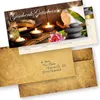 A gift voucher with a spa-themed image, including candles, stones, and a lotus flower, with an envelope addressed to a recipient. Produktbild-Vorschau