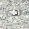 A modern outdoor wall light mounted on a brick wall. Produktbild-Vorschau