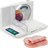 A white electric food slicer with a piece of meat being sliced and a stack of sliced ham in the foreground. Náhľad obrázku produktu