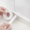 Hands applying white sealing tape to a corner joint between a wall and a countertop. Anteprima dell’immagine prodotto