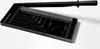 A black paper trimmer with a silver cutting guide and ruler markings is shown on a white background. Produktbild-Vorschau