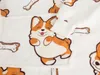 A close-up view of a white blanket with a repeating pattern of cartoon corgi puppies and dog bones. Anteprima dell’immagine prodotto