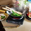 A portable infrared cooktop with a wok and green beans being cooked. Produktbild-Vorschau