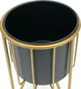 A close-up view of a black planter pot with a gold metal stand. Podgląd zdjęcia produktu