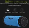 A blue and black portable Bluetooth speaker with water droplets on its surface, set against a black background. Produktbild-Vorschau