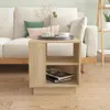 A wooden side table with books and cups on it, placed next to a sofa. Náhled obrázku produktu