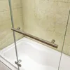A close-up view of a bathtub with a shower screen and a handle. Produktbild-Vorschau