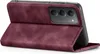 A close-up, angled view of a burgundy flip case for a smartphone, showing the camera cutout and the textured exterior. Produktbild-Vorschau