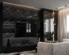 A modern living room with a large black marble-effect wall panel featuring a television and a black media console. A glass display cabinet with lighting is visible to the right, and a light-colored sofa is in the foreground. Anteprima dell’immagine prodotto