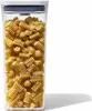 A clear, well-lit studio shot of a tall, clear plastic food storage container filled with fusilli pasta. The container has a dark blue lid. Náhled obrázku produktu