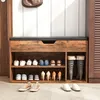 A shoe cabinet with a bench seat, displaying various shoes on its shelves. Náhled obrázku produktu