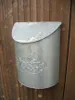 A galvanized metal mailbox is mounted on a wooden fence. Produktbild-Vorschau