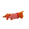 A plush dachshund toy wearing a red and white striped sweater, lying on a white background. Produktbild-Vorschau