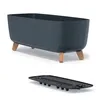 A dark gray planter with wooden legs is shown from a side angle, with a black drainage tray below it. Produktbild-Vorschau