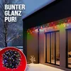 A house exterior at night, decorated with colorful Christmas lights along the roofline and a small decorative tree in the yard. A coiled string of lights is shown in a red circle in the lower left corner. Anteprima dell’immagine prodotto