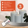Three LED candles of varying heights are displayed on a textured gray tray, with a remote control in the foreground and a sprig of greenery to the right. An orange overlay box on the left lists product features. Anteprima dell’immagine prodotto
