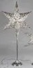 A silver star-shaped lamp on a stand. Produktbild-Vorschau
