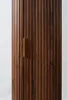 A close-up view of a dark brown wooden cabinet with vertical fluting and a gold handle. Anteprima dell’immagine prodotto