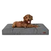 A brown dog is lying on a gray dog bed. Voir les images du produit