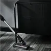 A vacuum cleaner head is shown on a wooden floor in front of a black cabinet. Voir les images du produit