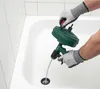 A person wearing gloves is using a drain snake in a bathtub. Produktbild-Vorschau